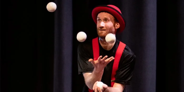Circus performer Janoah Bailin will teach you how to juggle as ze unicycles, balances, juggles, tells jokes and stories, and dances, featuring the scarves, and other juggling props. Photo by Roy Knight.